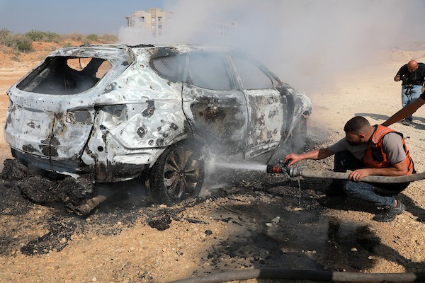 عناصر من الدفاع المدني وفلسطينيون نازحون يعملون على إخماد حريق اندلع في سيارة عقب غارة إسرائيلية على شارع الرشيد، جنوب غرب مدينة غزة، قطاع غزة، في 13 أغسطس/آب 2026.صورة: أحمد إبراهيم