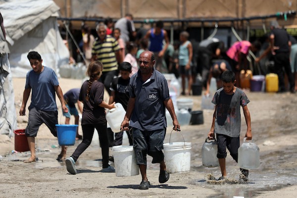 فلسطينيون نازحون يتجمعون للحصول على المياه في مخيم على شاطئ مدينة غزة، في 12 أغسطس/آب 2026. (صورة: أسامة)