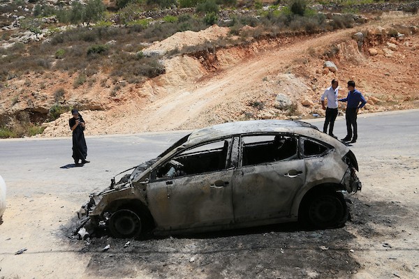فلسطينيون يعاينون سيارات محترقة عقب هجوم لمستوطنين إسرائيليين استهدف منازل وممتلكات وخطوط كهرباء بين قريتي جالود وتلفيت، قرب نابلس، في 4 أغسطس/آب 2026. (تصوير: محمد ناصر)