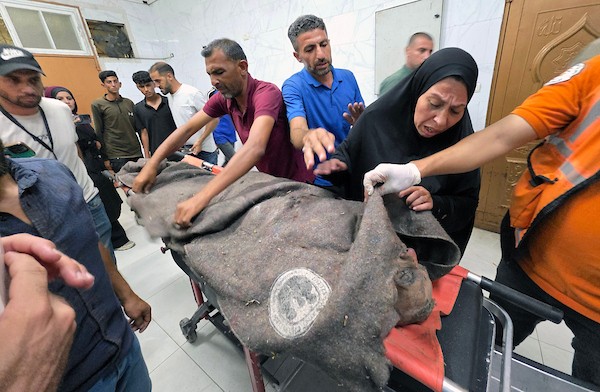 فلسطينيون ينقلون جثمان شاب وستة جرحى، بينهم أطفال، إلى مجمع ناصر الطبي عقب غارة إسرائيلية استهدفت سطح منزل في مخيم خان يونس للاجئين، جنوب قطاع غزة، في 24 أغسطس/آب 2026. صورة: طارق محمد