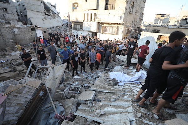 فلسطينيون يتجمعون في موقع غارة إسرائيلية استهدفت منزلاً في مخيم البريج للاجئين وسط قطاع غزة، بينما يتصاعد الدخان من المكان، في 24 أغسطس/آب 2026. الصورة: حسن الجدي