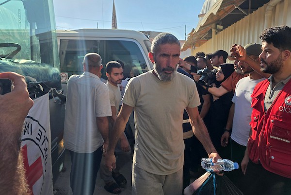 أسرى ومعتقلون فلسطينيون مفرج عنهم يصلون على متن حافلات تابعة للجنة الدولية للصليب الأحمر إلى مجمع ناصر الطبي في خان يونس، جنوب قطاع غزة، بعد نقلهم من معبر كرم أبو سالم، وسط تجمع أفراد من عائلاتهم لاستقبالهم.(تصوير: طارق محمد)