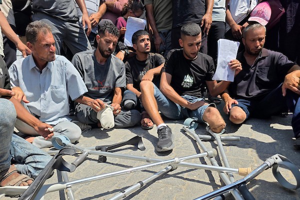 مرضى وجرحى فلسطينيون يشاركون في وقفة أمام مجمع ناصر الطبي في خان يونس، جنوب قطاع غزة، في 9 أغسطس/آب 2026، مطالبين بفتح المعابر والسماح لهم بمغادرة القطاع لاستكمال العلاج، في ظل تراجع أعداد المسافرين وتراكم طلبات الإحالة الطبية. (تصوير: طارق محمد)