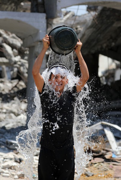 أطفال فلسطينيون نازحون يرتشفون الماء قرب مخيمات النزوح بجوار حي الشجاعية، شرق مدينة غزة، في 9 أغسطس/آب 2026، وسط ارتفاع درجات الحرارة وظروف معيشية صعبة في الخيام ومحدودية وسائل التبريد والخدمات الأساسية. (تصوير: بلال أسامة)