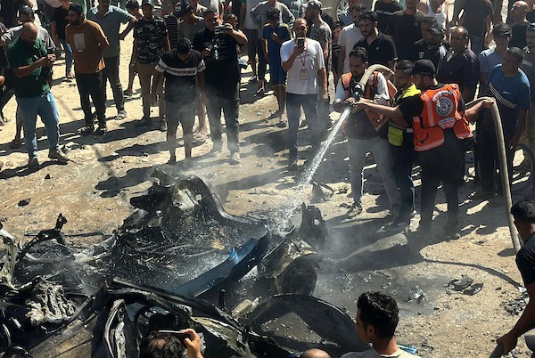 تجمّع فلسطينيون في موقع غارة إسرائيلية استهدفت مركبة مدنية في حي تل الهوى بمدينة غزة في 31 أغسطس/آب 2026، بينما يحاول رجال الإطفاء إخماد حريق اندلع في الموقع. وانتشلت فرق الإسعاف جثث ثلاثة فلسطينيين استشهدوا في الغارة. (صورة: هادي داود)