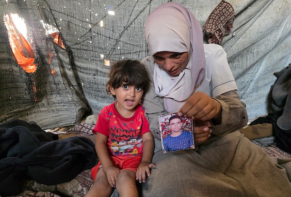 الفلسطينية فاطمة النجار تحمل صورة شقيقها محمد داخل خيمة للنازحين في خان يونس، جنوب قطاع غزة، في 30 أغسطس/آب 2026، بينما تواصل انتظار أي خبر عن مصيره في اليوم الدولي للمفقودين. تصوير: طارق محمد