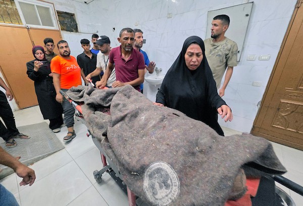 فلسطينيون ينقلون جثمان شاب وستة جرحى، بينهم أطفال، إلى مجمع ناصر الطبي عقب غارة إسرائيلية استهدفت سطح منزل في مخيم خان يونس للاجئين، جنوب قطاع غزة، في 24 أغسطس/آب 2026. صورة: طارق محمد