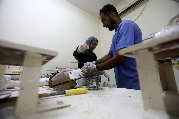 أخصائيون فلسطينيون يصنعون ويجهزون أطرافًا اصطناعية لجرحى الحرب ومبتوري الأطراف في مركز تديره بلدية غزة بمدينة غزة، في 11 أغسطس/آب 2026. (صورة: بلال أسامة)