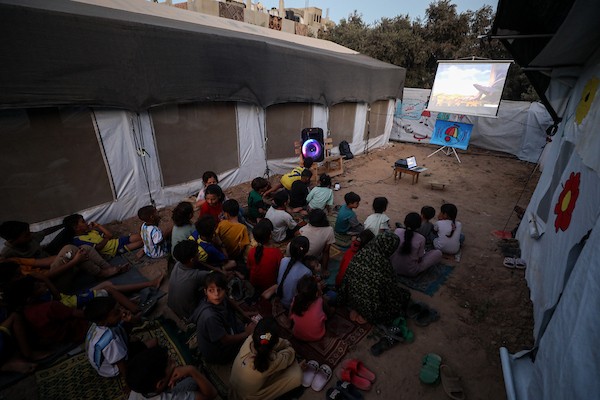 أطفال فلسطينيون يشاهدون رسومًا متحركة في مخيم النصيرات للاجئين وسط قطاع غزة، في 18 سبتمبر/أيلول 2026. تصوير: حسن الجدي