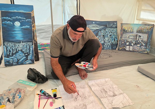 الفنان الفلسطيني جهاد الشرافي يرسم داخل خيمة للنازحين في خان يونس جنوبي قطاع غزة، مشاهد توثق الحرب والجوع ونقص المياه والدمار، في 18 سبتمبر/أيلول 2026. تصوير: طارق محمد