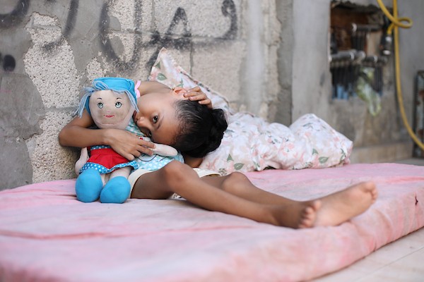 الطفلة سيلا أبو كريم، 6 أعوام، تجلس داخل منزل متضرر في مخيم المغازي وسط قطاع غزة، في 3 سبتمبر/أيلول 2026، بعدما تسببت شظايا غارة إسرائيلية سابقة بإصابات في فقرات ظهرها وعمودها الفقري. تصوير: حسن الجدي.