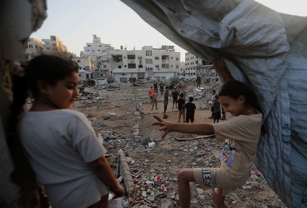 أطفال فلسطينيون يلعبون الكرة الطائرة على ملعب أُقيم بين أنقاض المباني التي دمرتها الحرب في مدينة غزة في 16 سبتمبر/أيلول 2026. صورة: بلال أسامة