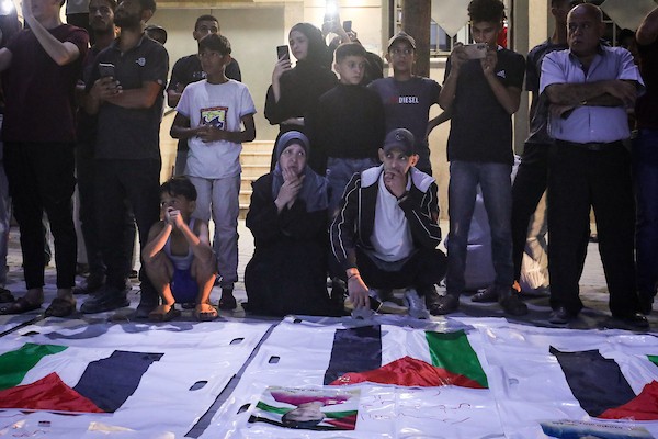 فلسطينيون يشعلون الشموع أمام مستشفى العودة في مخيم النصيرات وسط قطاع غزة، في 28 سبتمبر/أيلول 2026، خلال وداع رفات شهداء. (صورة: معز صالحي)