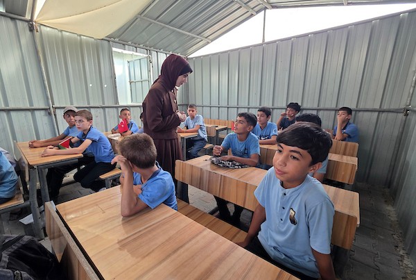 طلبة فلسطينيون يباشرون عامهم الدراسي الجديد داخل خيام وفصول مؤقتة مصنوعة من الصفيح في خان يونس جنوب قطاع غزة، في 19 أيلول/ سبتمبر 2026. (تصوير: طارق محمد)