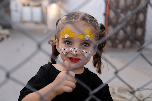 تجمّع أطفال فلسطينيون لمشاهدة عرض فيلم كرتوني في الهواء الطلق على شاشة نُصبت بين المباني المتضررة في مخيم للنازحين بحي النصر في مدينة غزة، وذلك في 2 سبتمبر/أيلول 2026.(صورة: بلال أسامة)