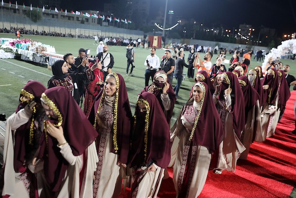 عرسان يشاركون في حفل زفاف جماعي ضم 44 زوجًا في مدينة دورا قرب الخليل، في 26 سبتمبر/أيلول 2026. تصوير: مأمون وزواز.