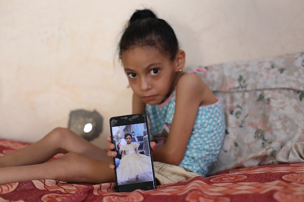 الطفلة سيلا أبو كريم، 6 أعوام، تجلس داخل منزل متضرر في مخيم المغازي وسط قطاع غزة، في 3 سبتمبر/أيلول 2026، بعدما تسببت شظايا غارة إسرائيلية سابقة بإصابات في فقرات ظهرها وعمودها الفقري. تصوير: حسن الجدي.