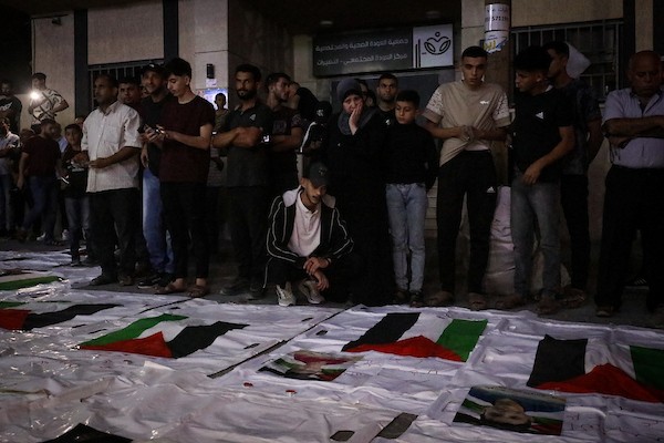 فلسطينيون يشعلون الشموع أمام مستشفى العودة في مخيم النصيرات وسط قطاع غزة، في 28 سبتمبر/أيلول 2026، خلال وداع رفات شهداء. (صورة: معز صالحي)