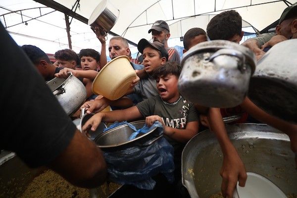 فلسطينيون نازحون، ينتظرون الحصول على وجبات ساخنة في مخيم النصيرات للاجئين وسط قطاع غزة، في 28 سبتمبر/أيلول 2026. (صورة: حسن الجدي)