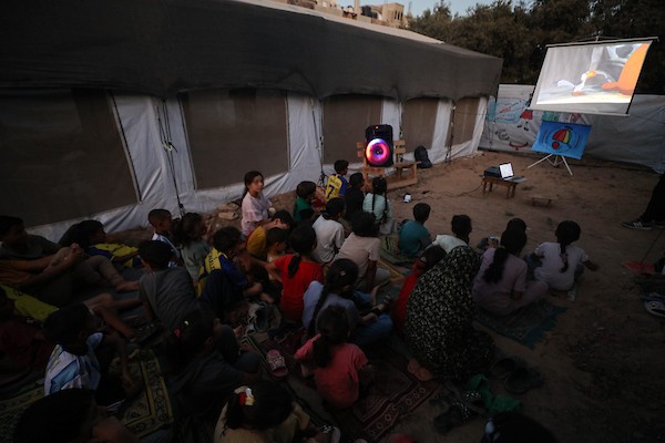 أطفال فلسطينيون يشاهدون رسومًا متحركة في مخيم النصيرات للاجئين وسط قطاع غزة، في 18 سبتمبر/أيلول 2026. تصوير: حسن الجدي