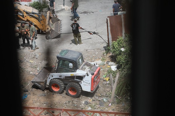مستوطنون ينفذون أعمال تجريف في شارع الشلالة في البلدة القديمة بالخليل، بحماية قوات الاحتلال، في 31 آب/أغسطس 2026. (تصوير: مأمون وزواز)
