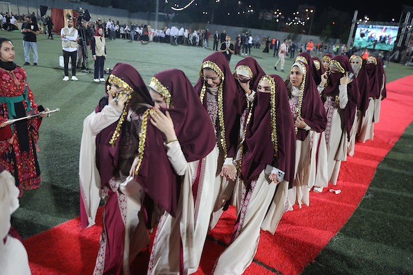 عرسان يشاركون في حفل زفاف جماعي ضم 44 زوجًا في مدينة دورا قرب الخليل، في 26 سبتمبر/أيلول 2026. تصوير: مأمون وزواز.