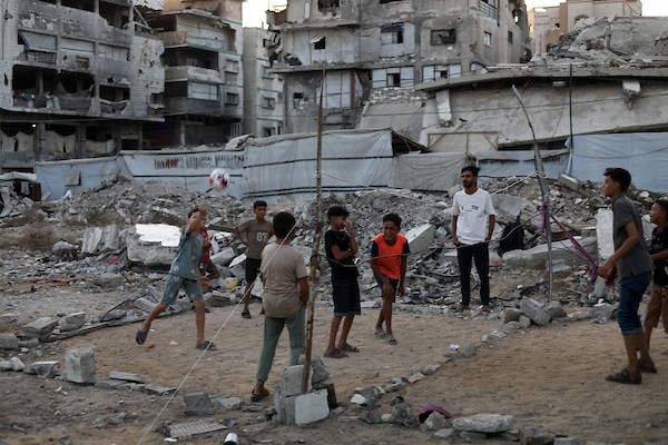 أطفال فلسطينيون يلعبون الكرة الطائرة على ملعب أُقيم بين أنقاض المباني التي دمرتها الحرب في مدينة غزة في 16 سبتمبر/أيلول 2026. صورة: بلال أسامة