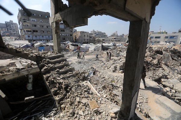 عمال فلسطينيون يزيلون أنقاض منزل دُمر في غارة إسرائيلية خلال الحرب في حي الرمال بمدينة غزة، في 14 سبتمبر/أيلول 2026. تصوير: بلال أسامة.