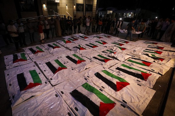 فلسطينيون يشعلون الشموع أمام مستشفى العودة في مخيم النصيرات وسط قطاع غزة، في 28 سبتمبر/أيلول 2026، خلال وداع رفات شهداء. (صورة: معز صالحي)
