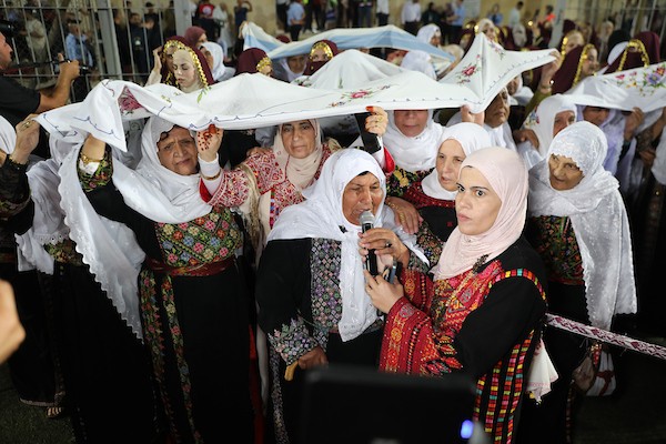 عرسان يشاركون في حفل زفاف جماعي ضم 44 زوجًا في مدينة دورا قرب الخليل، في 26 سبتمبر/أيلول 2026. تصوير: مأمون وزواز.