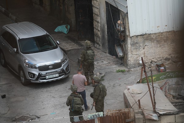 مستوطنون ينفذون أعمال تجريف في شارع الشلالة في البلدة القديمة بالخليل، بحماية قوات الاحتلال، في 31 آب/أغسطس 2026. (تصوير: مأمون وزواز)
