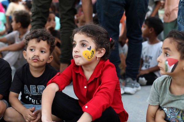 تجمّع أطفال فلسطينيون لمشاهدة عرض فيلم كرتوني في الهواء الطلق على شاشة نُصبت بين المباني المتضررة في مخيم للنازحين بحي النصر في مدينة غزة، وذلك في 2 سبتمبر/أيلول 2026.(صورة: بلال أسامة)