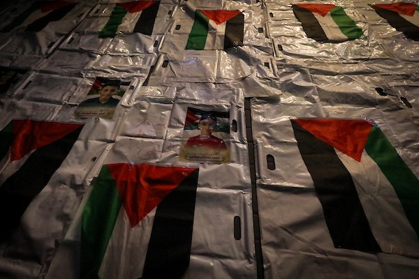 فلسطينيون يشعلون الشموع أمام مستشفى العودة في مخيم النصيرات وسط قطاع غزة، في 28 سبتمبر/أيلول 2026، خلال وداع رفات شهداء. (صورة: معز صالحي)