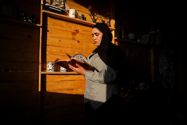 تعمل الصحفية والمذيعة الفلسطينية تالا درويش، داخل استوديو مؤقت بنته من ألواح خشبية مأخوذة من صناديق المساعدات في مخيم النصيرات للاجئين وسط قطاع غزة.تصوير: معز صالحي