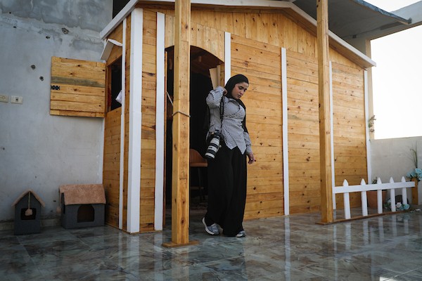 تعمل الصحفية والمذيعة الفلسطينية تالا درويش، داخل استوديو مؤقت بنته من ألواح خشبية مأخوذة من صناديق المساعدات في مخيم النصيرات للاجئين وسط قطاع غزة.تصوير: معز صالحي