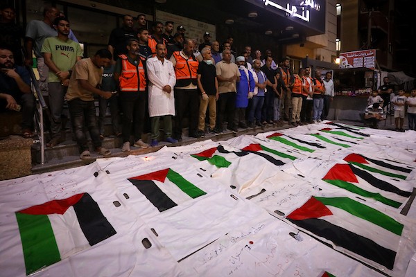 فلسطينيون يشعلون الشموع أمام مستشفى العودة في مخيم النصيرات وسط قطاع غزة، في 28 سبتمبر/أيلول 2026، خلال وداع رفات شهداء. (صورة: معز صالحي)
