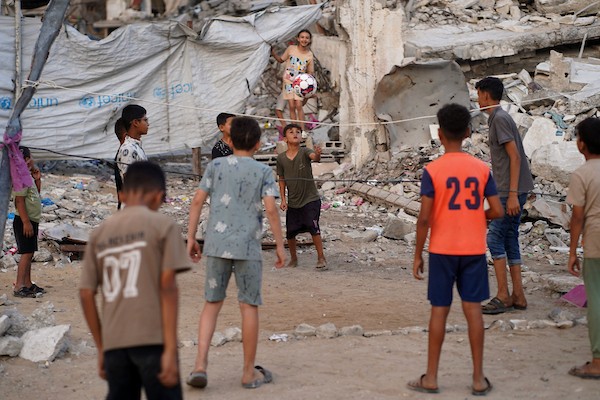 أطفال فلسطينيون يلعبون الكرة الطائرة على ملعب أُقيم بين أنقاض المباني التي دمرتها الحرب في مدينة غزة في 16 سبتمبر/أيلول 2026. صورة: بلال أسامة