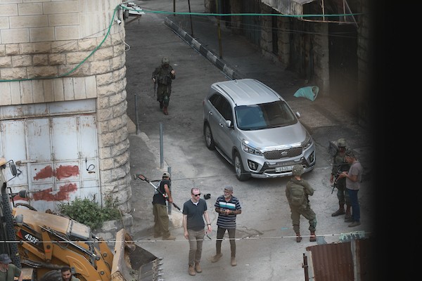 مستوطنون ينفذون أعمال تجريف في شارع الشلالة في البلدة القديمة بالخليل، بحماية قوات الاحتلال، في 31 آب/أغسطس 2026. (تصوير: مأمون وزواز)