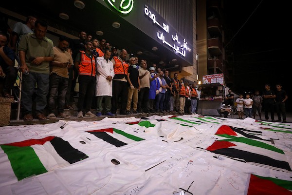 فلسطينيون يشعلون الشموع أمام مستشفى العودة في مخيم النصيرات وسط قطاع غزة، في 28 سبتمبر/أيلول 2026، خلال وداع رفات شهداء. (صورة: معز صالحي)
