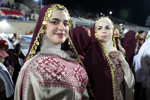 عرسان يشاركون في حفل زفاف جماعي ضم 44 زوجًا في مدينة دورا قرب الخليل، في 26 سبتمبر/أيلول 2026. تصوير: مأمون وزواز.