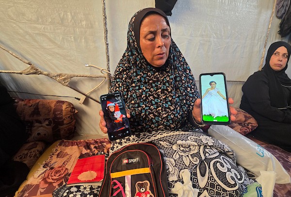 سحر المغير تحمل صورة ابنتها أمل، 8 سنوات، إلى جانب حقيبتها ومستلزماتها المدرسية في خان يونس جنوب قطاع غزة، في 19 أيلول/ سبتمبر 2026. (تصوير: طارق محمد)