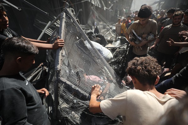 فلسطينيون يتفقدون مبنىً دُمر في غارة جوية إسرائيلية بمخيم النصيرات للاجئين وسط قطاع غزة في 9 سبتمبر/أيلول. صورة: حسن الجدي