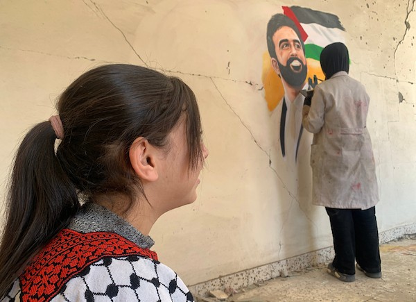 الفنانة الفلسطينية أسيل نسمان ترسم عملًا فنيًا على أنقاض منازل مدمرة في قطاع غزة، في 24 سبتمبر/أيلول 2026. (صورة: محمد صالحة)