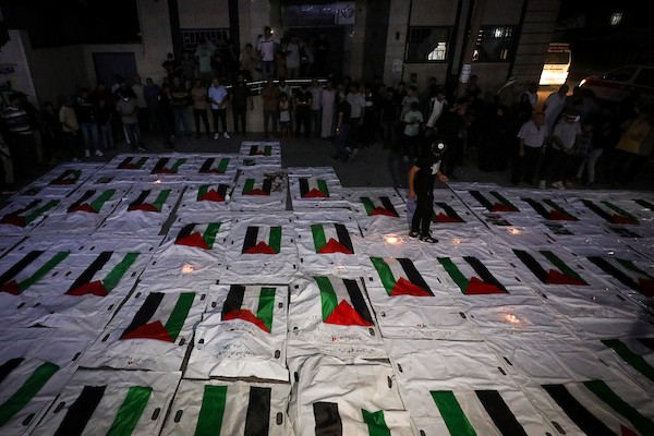 فلسطينيون يشعلون الشموع أمام مستشفى العودة في مخيم النصيرات وسط قطاع غزة، في 28 سبتمبر/أيلول 2026، خلال وداع رفات شهداء. (صورة: معز صالحي)