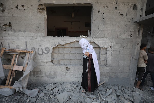 فلسطينيون يتفقدون مبنىً دُمر في غارة جوية إسرائيلية بمخيم النصيرات للاجئين وسط قطاع غزة في 9 سبتمبر/أيلول. صورة: حسن الجدي