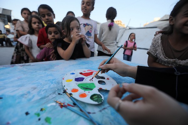 تجمّع أطفال فلسطينيون لمشاهدة عرض فيلم كرتوني في الهواء الطلق على شاشة نُصبت بين المباني المتضررة في مخيم للنازحين بحي النصر في مدينة غزة، وذلك في 2 سبتمبر/أيلول 2026.(صورة: بلال أسامة)