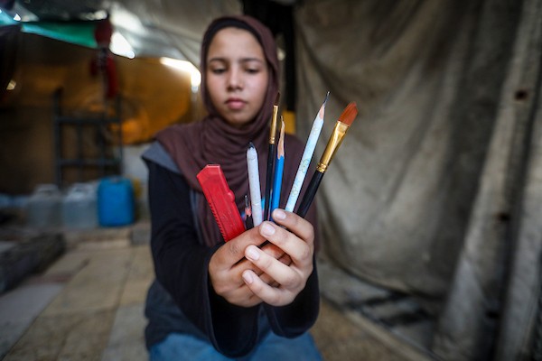 رغد حداد، فتاة فلسطينية تبلغ من العمر 16 عامًا، ترسم داخل خيمة للنازحين في حي الشيخ رضوان بمدينة غزة في 23 سبتمبر/أيلول 2026. تصوير: بلال أسامة
