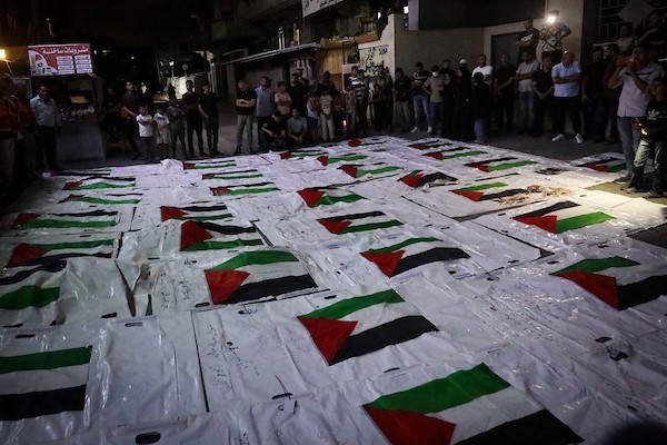 فلسطينيون يشعلون الشموع أمام مستشفى العودة في مخيم النصيرات وسط قطاع غزة، في 28 سبتمبر/أيلول 2026، خلال وداع رفات شهداء. (صورة: معز صالحي)