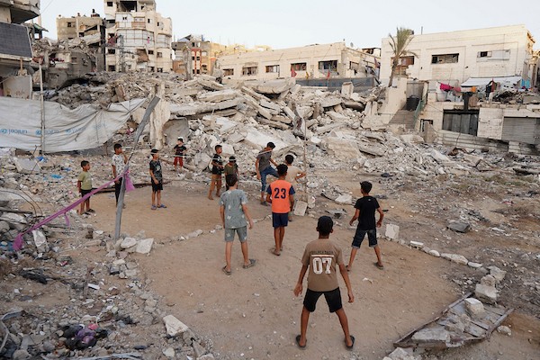 أطفال فلسطينيون يلعبون الكرة الطائرة على ملعب أُقيم بين أنقاض المباني التي دمرتها الحرب في مدينة غزة في 16 سبتمبر/أيلول 2026. صورة: بلال أسامة