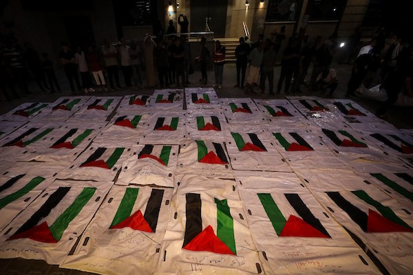 فلسطينيون يشعلون الشموع أمام مستشفى العودة في مخيم النصيرات وسط قطاع غزة، في 28 سبتمبر/أيلول 2026، خلال وداع رفات شهداء. (صورة: معز صالحي)